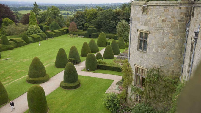 View of the garden at Chirk Castle, Wrexham, with topiary hedges and the edge of the castle just visible